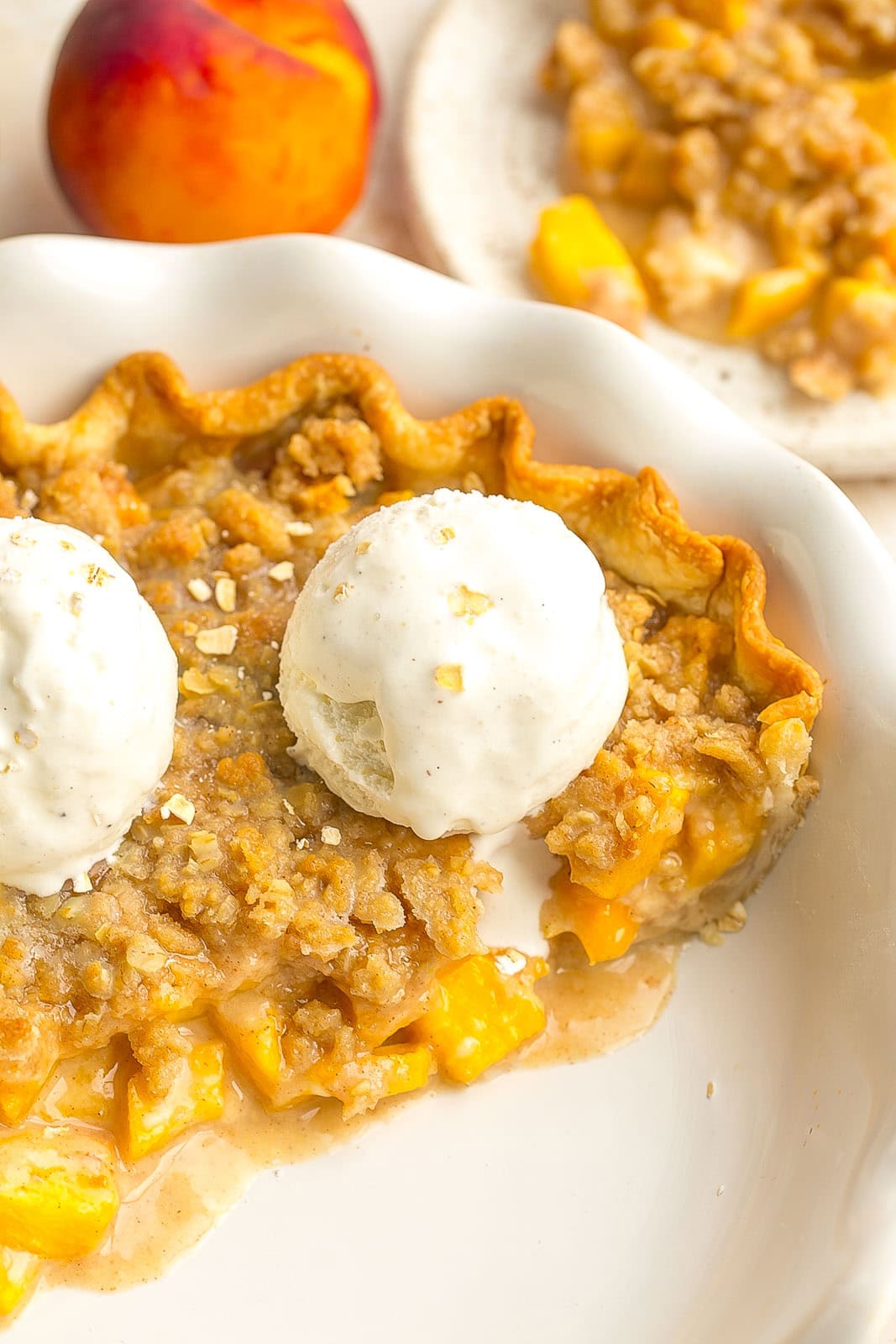 This Peach Crumble Pie is made with juicy peaches, flakey buttery pie crust and a brown sugar crumble topping that's perfectly crisp and sweetened. It's the best of both worlds for pie and crumble dessert lovers!

