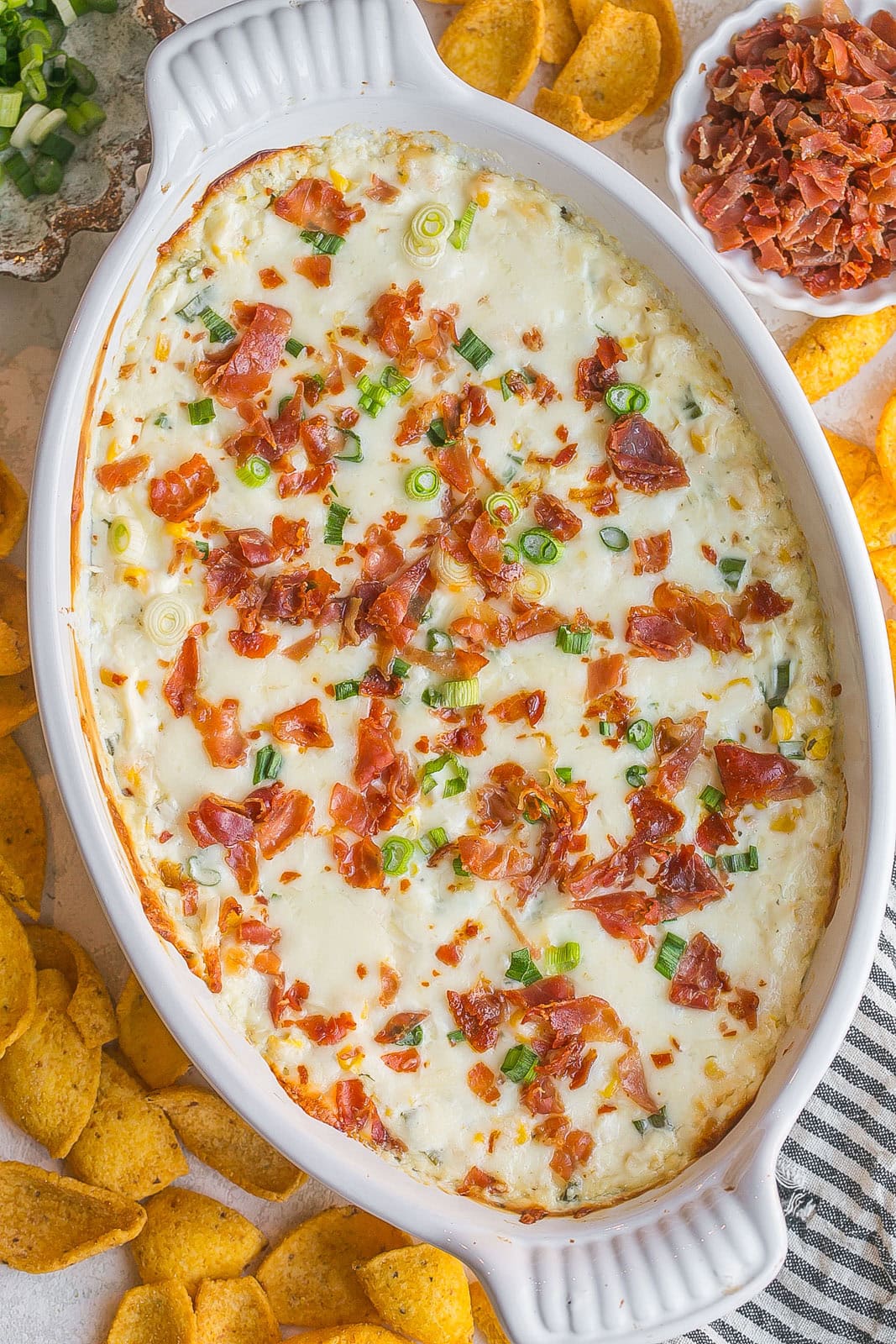 Top of cheesy corn dip with crispy bacon pieces.