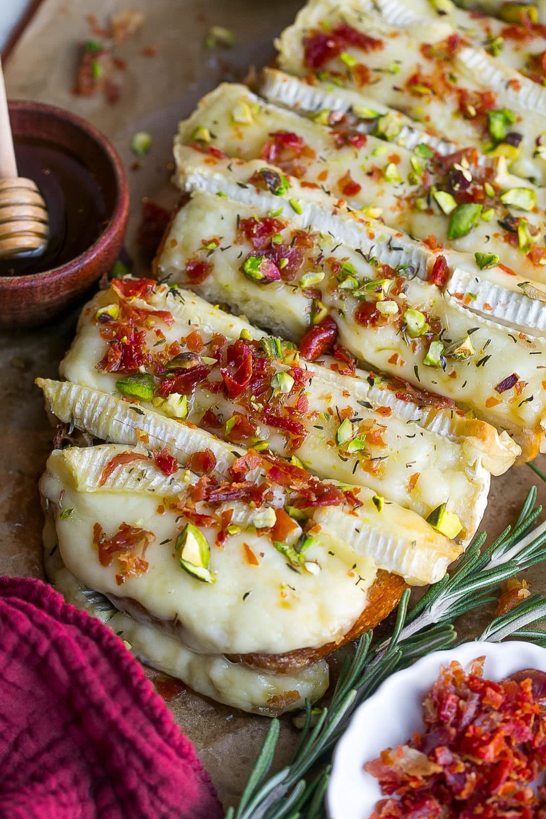 Close up view of baked bread with brie cheese, prosciutto and pistachios.