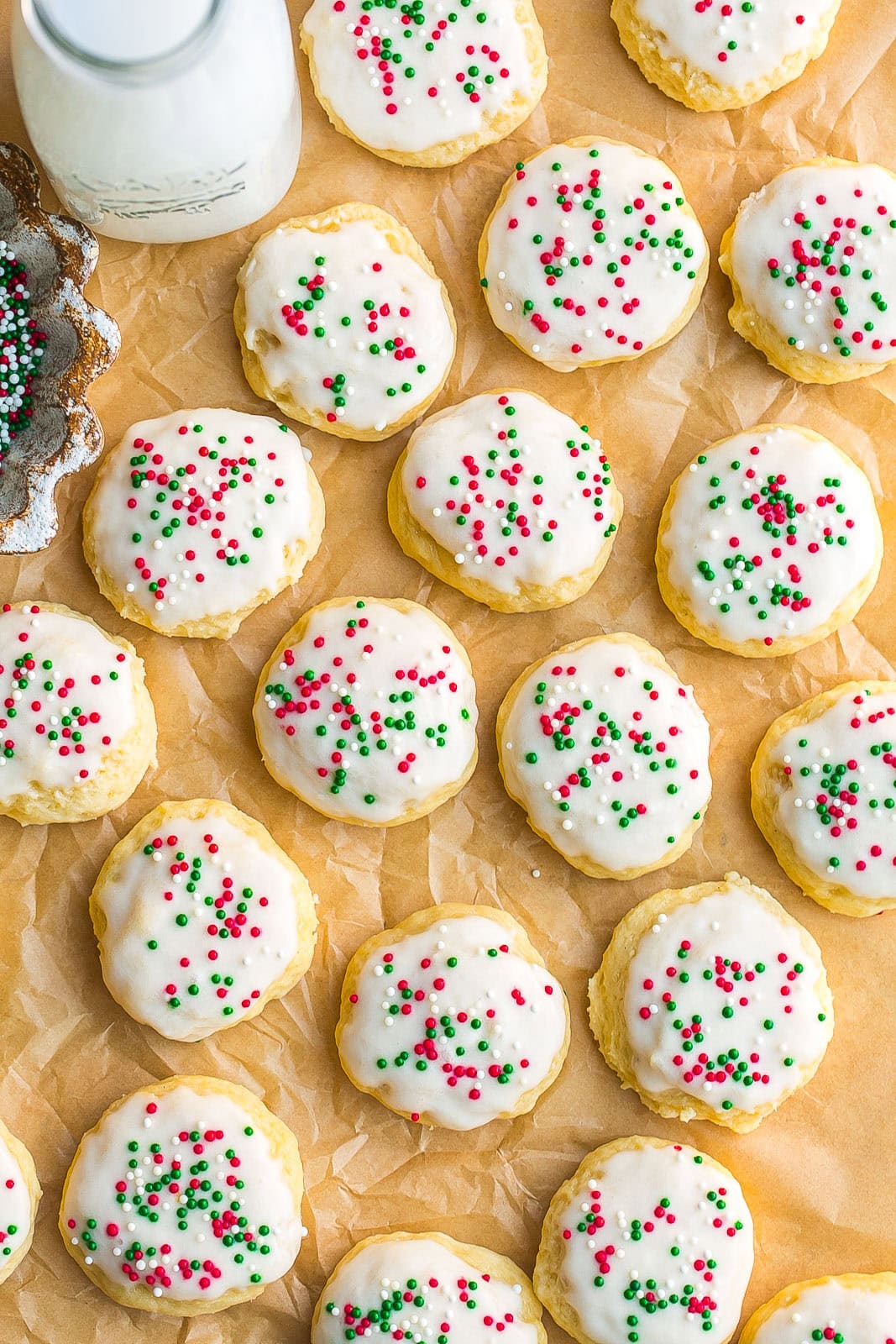 Frosted Sour Cream Cookies with parchment paper.