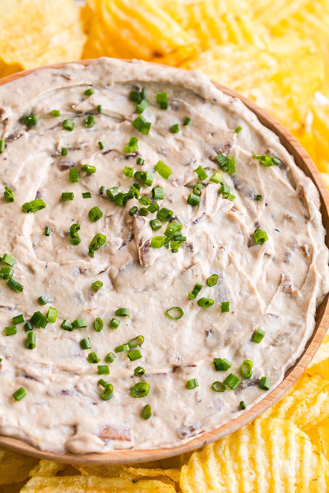 A bowl of French Onion dip made with caramelized onions and topped with fresh chives.