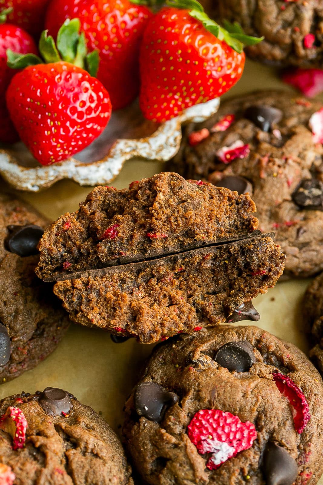 Chocolate cookie with freeze dried strawberries cut in half.