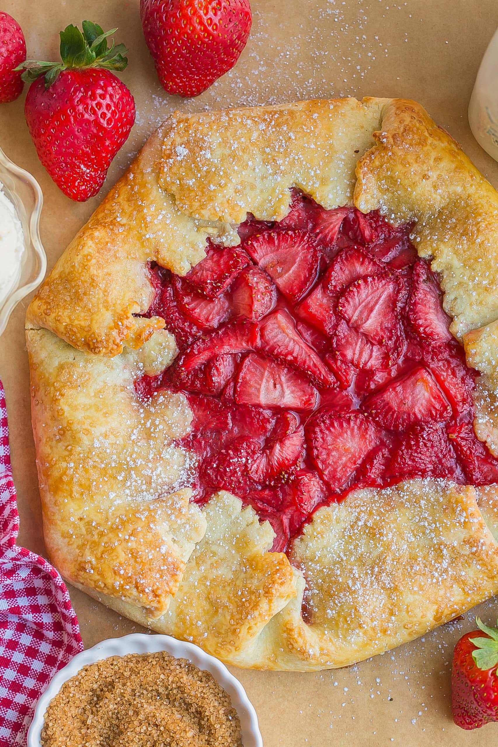 Birds eye view of strawberry galette on parchment paper.