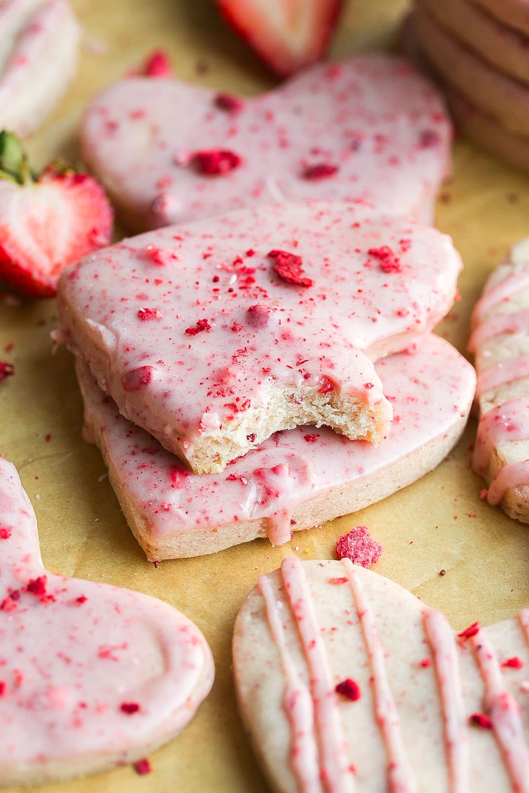A bite mark in a iced Strawberry Shortbread Cookie.