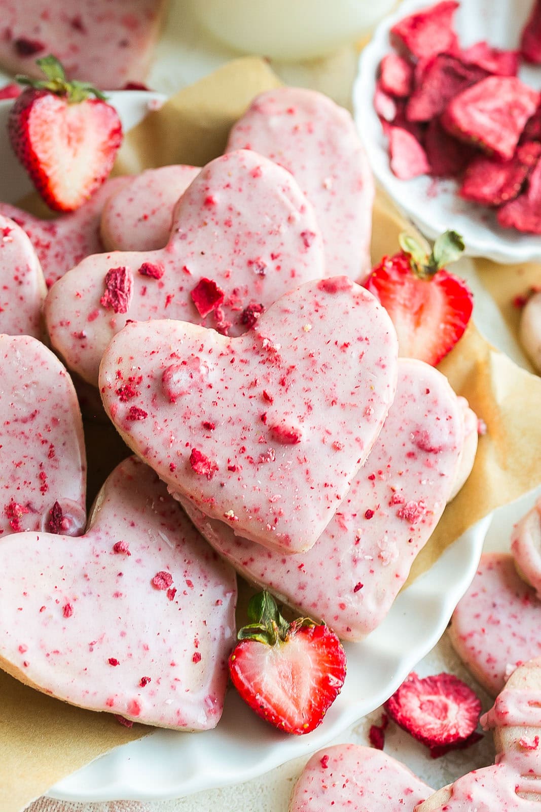 A plate full of buttery shortbread cookies with freeze dried strawberries.