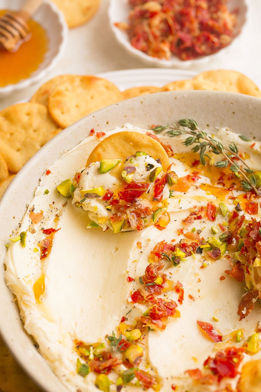 The best brie cheese dip with a cracker going through the dip.