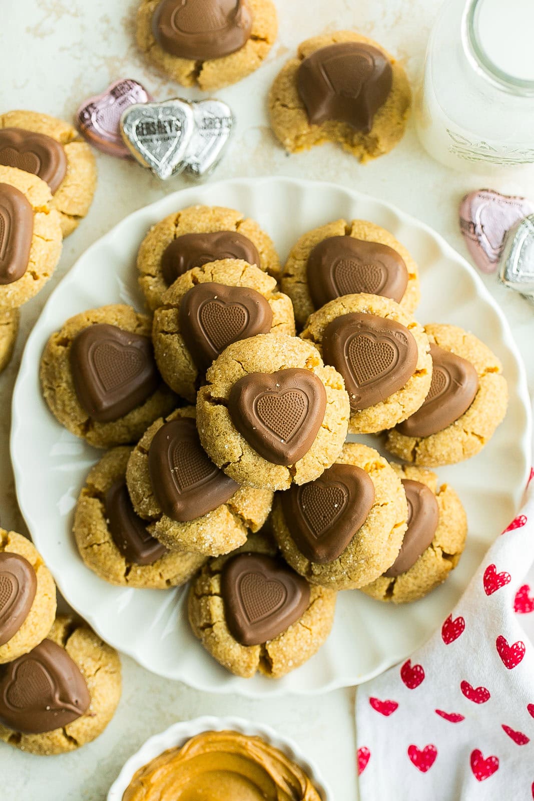 Birdseye view of Peanut butter cookies with chocolate hearts on white plate.