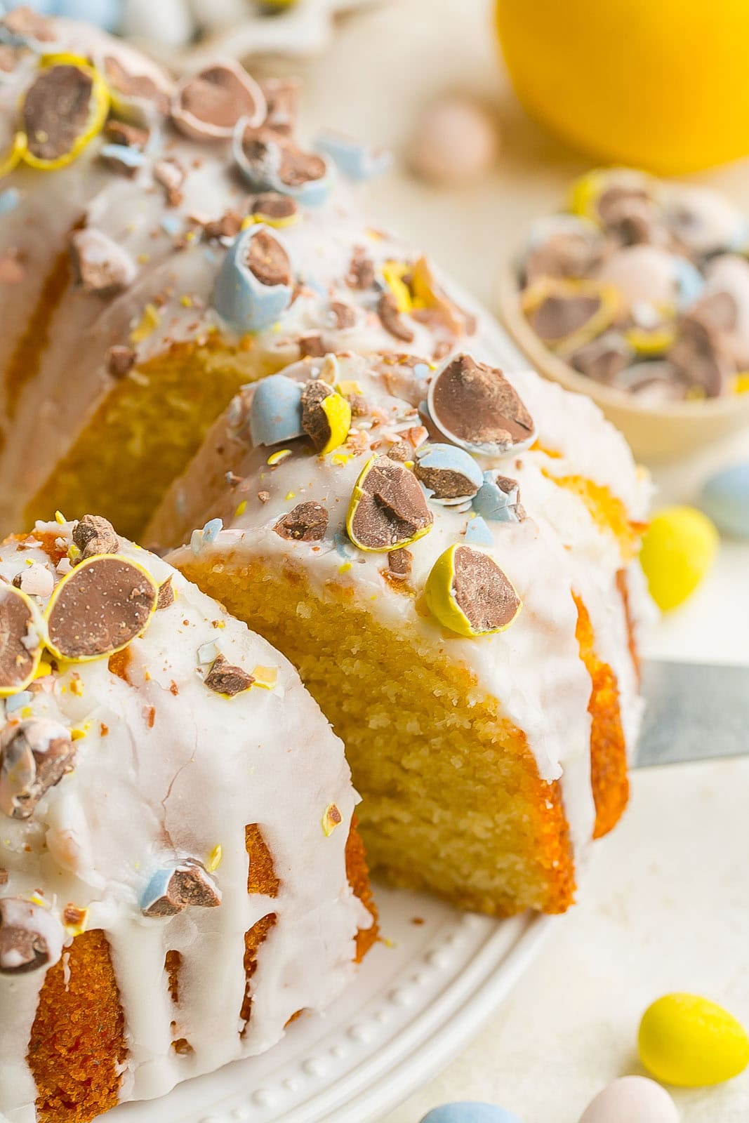 Lemon buttermilk bundt cake with slice being removed from it.