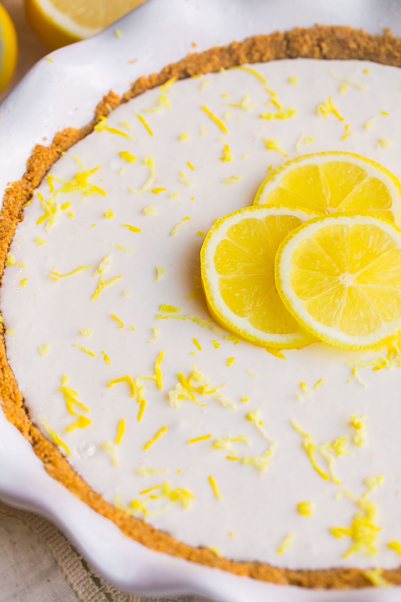 Side view of Cream Cheese Lemonade Pie in white pie dish.
