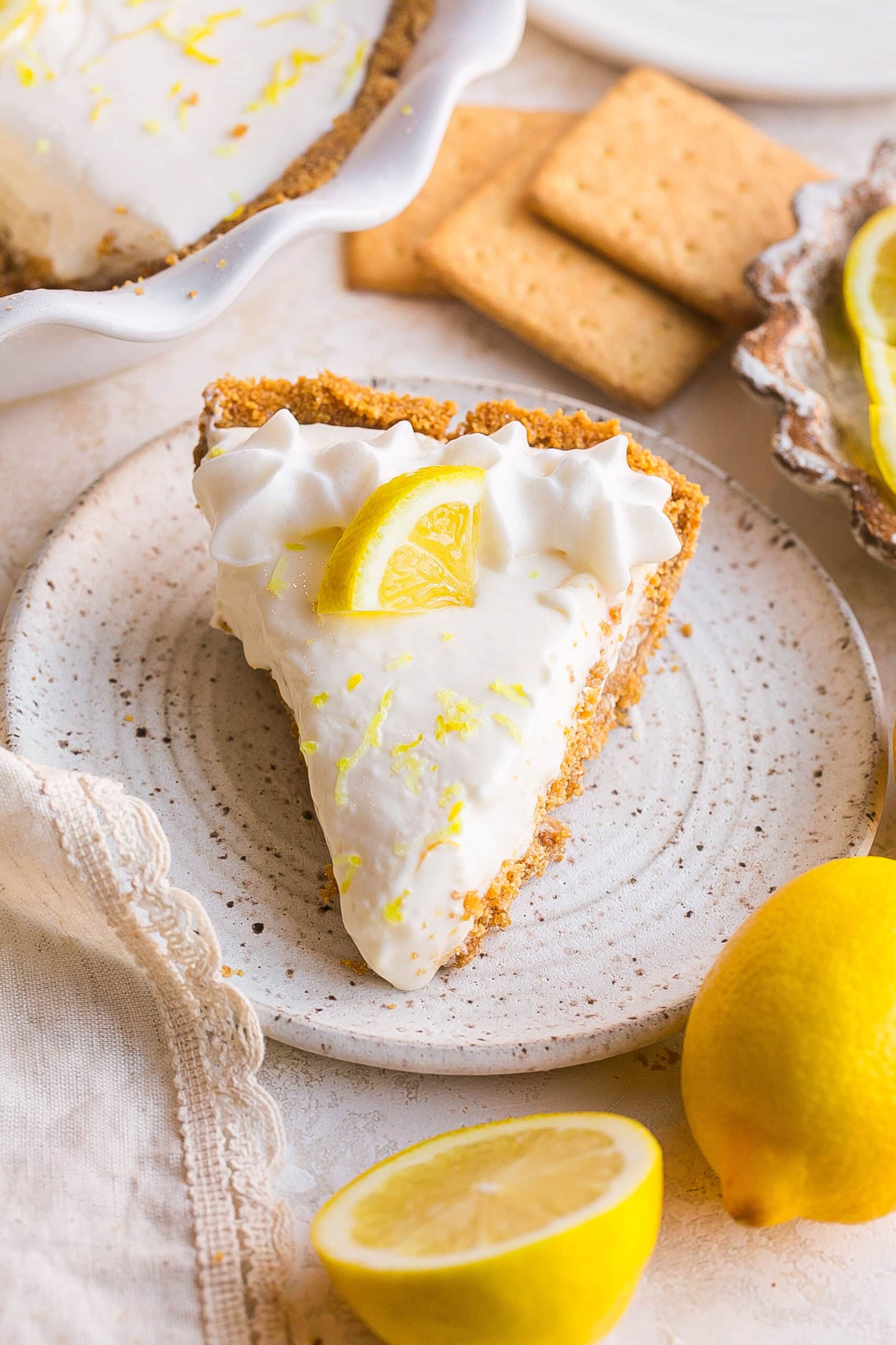 Creamy no bake Lemonade Pie with Cream Cheese in a graham cracker crust topped with fresh lemon slice.