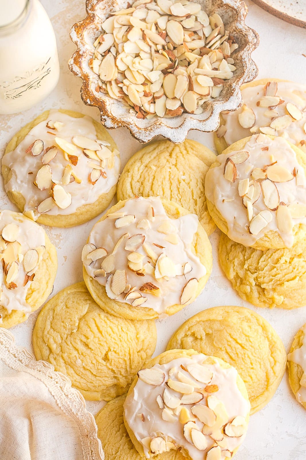 Buttery almond cookies with almond icing and sliced almonds on top.