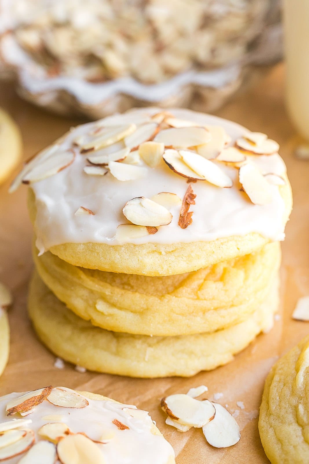 A tall stack of homemade almond sugar cookies with sliced almonds on top.