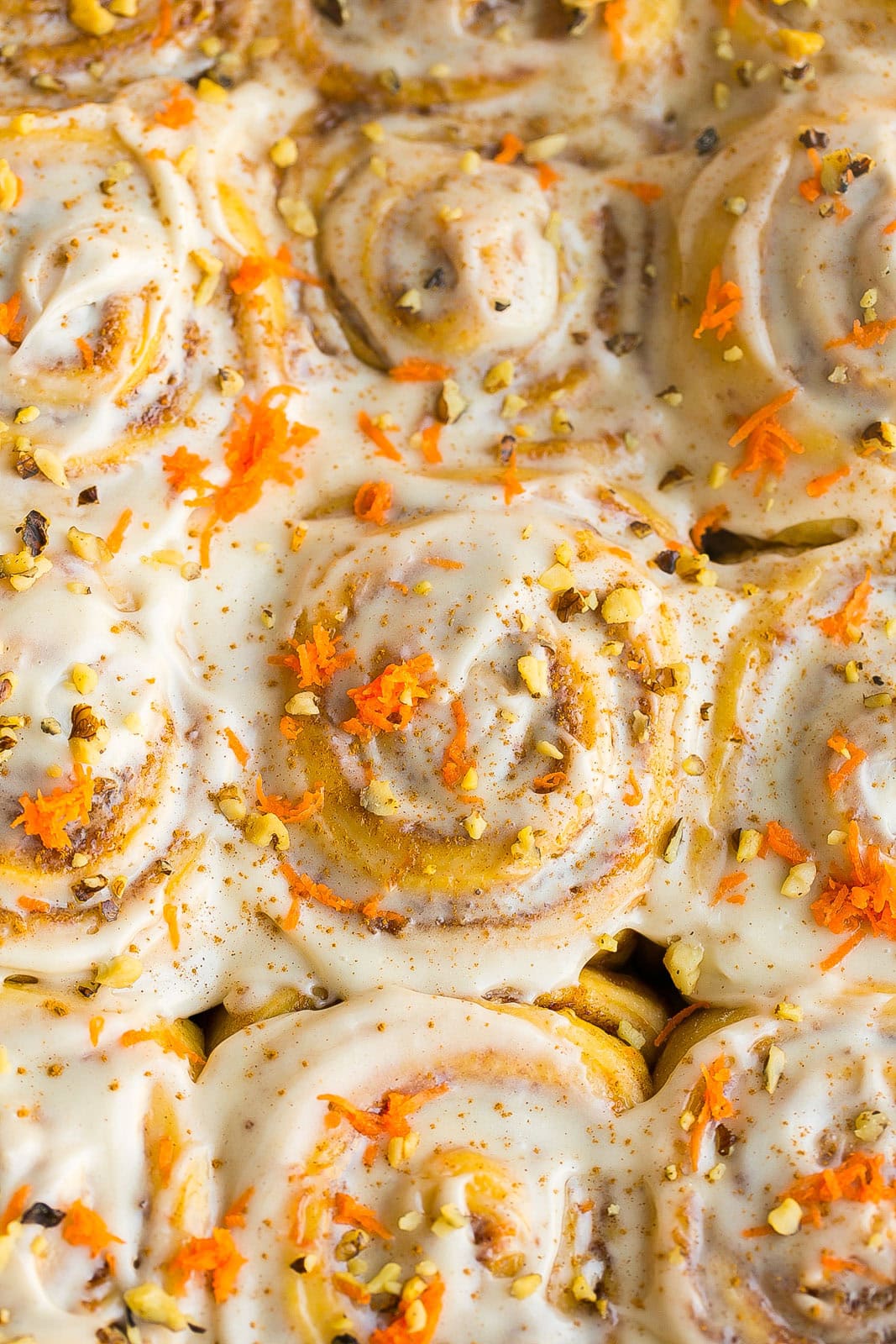 Cinnamon rolls with carrots in baking dish.