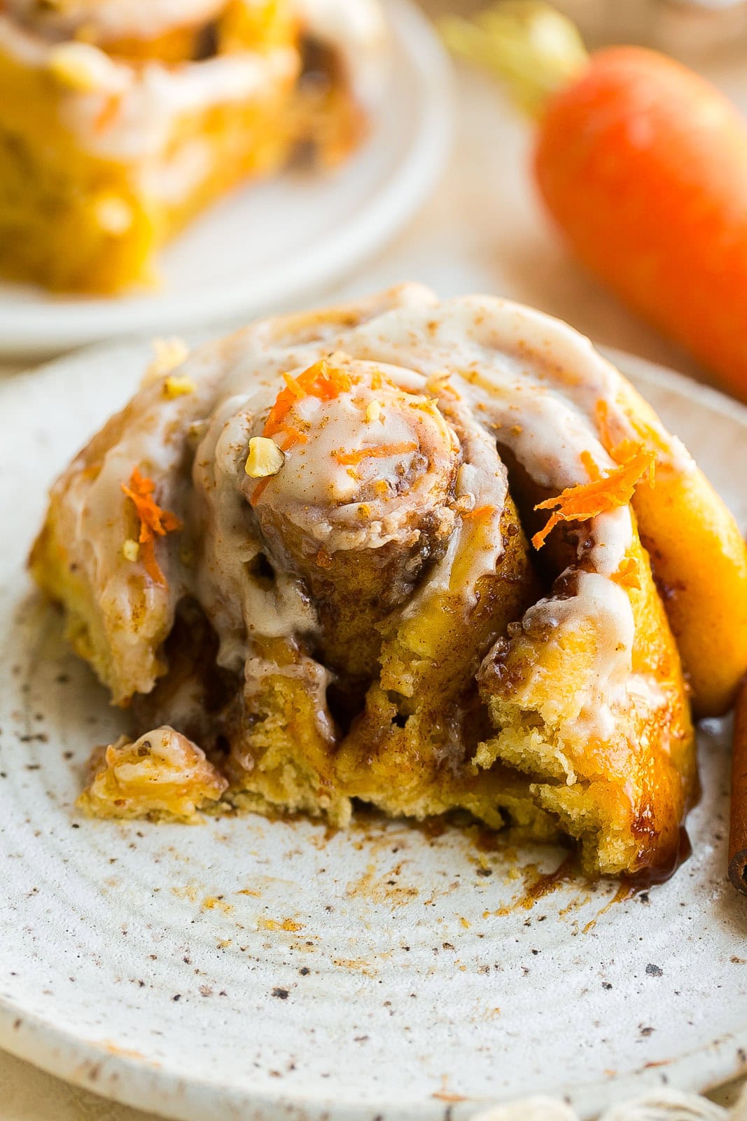 An extra gooey cinnamon roll on a dish with the center cut.