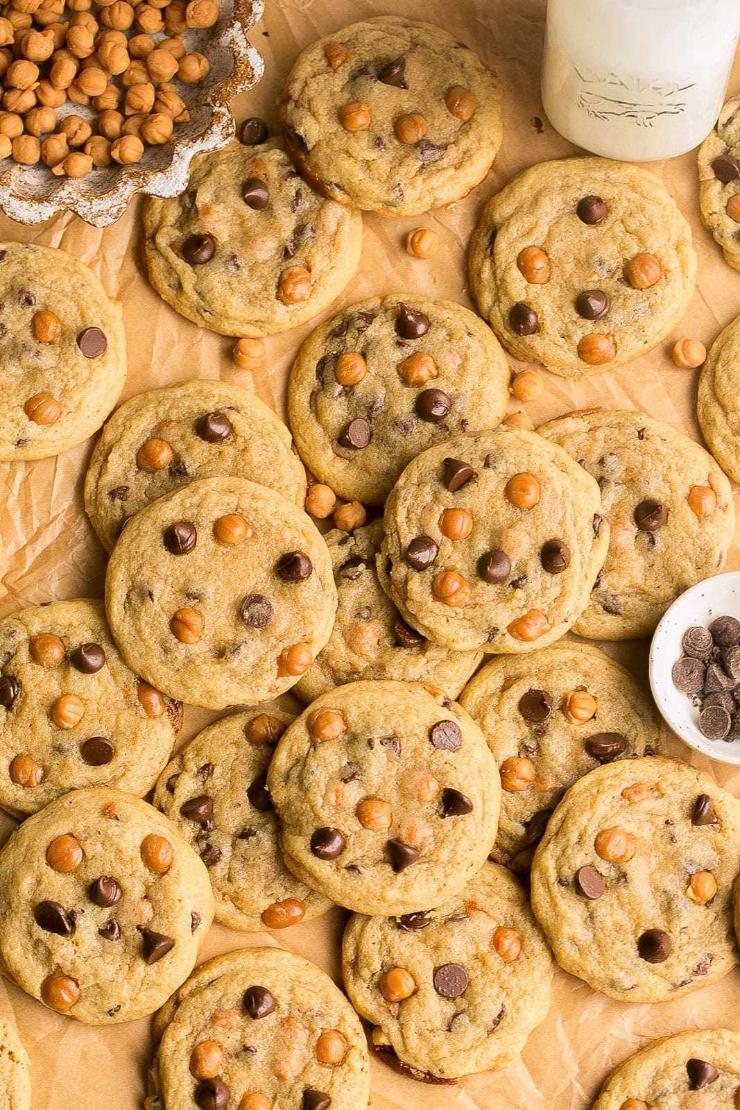 Parchment paper loaded with fresh baked chocolate chip cookies with caramel bits.