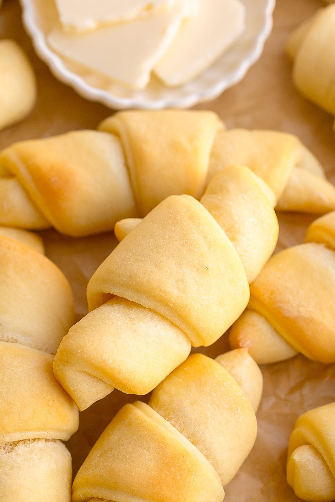 A perfect homemade crescent roll fresh from the oven with melted butter brushed on top.