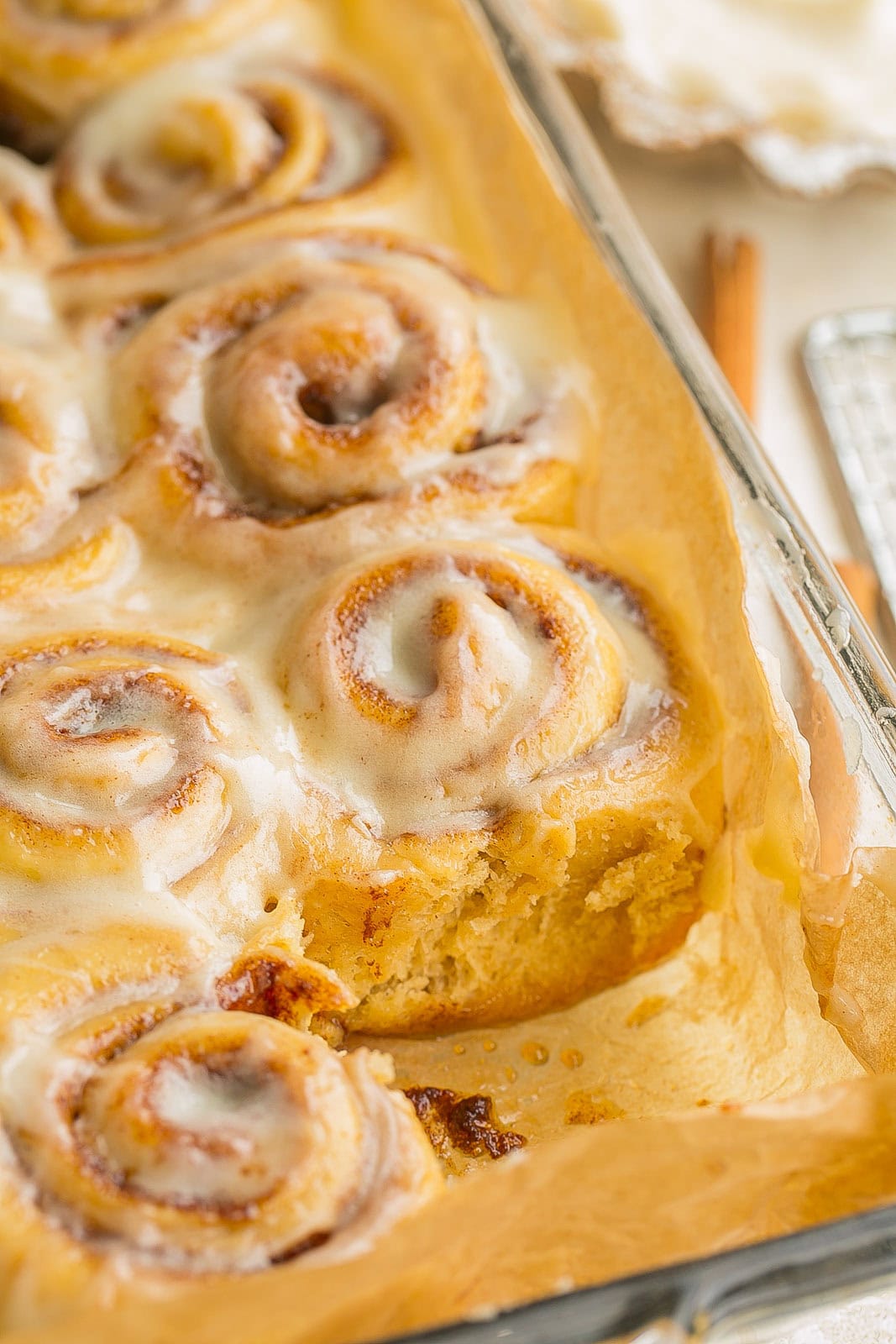 Mini Cinnamon Rolls in a baking pan with frosting on top.