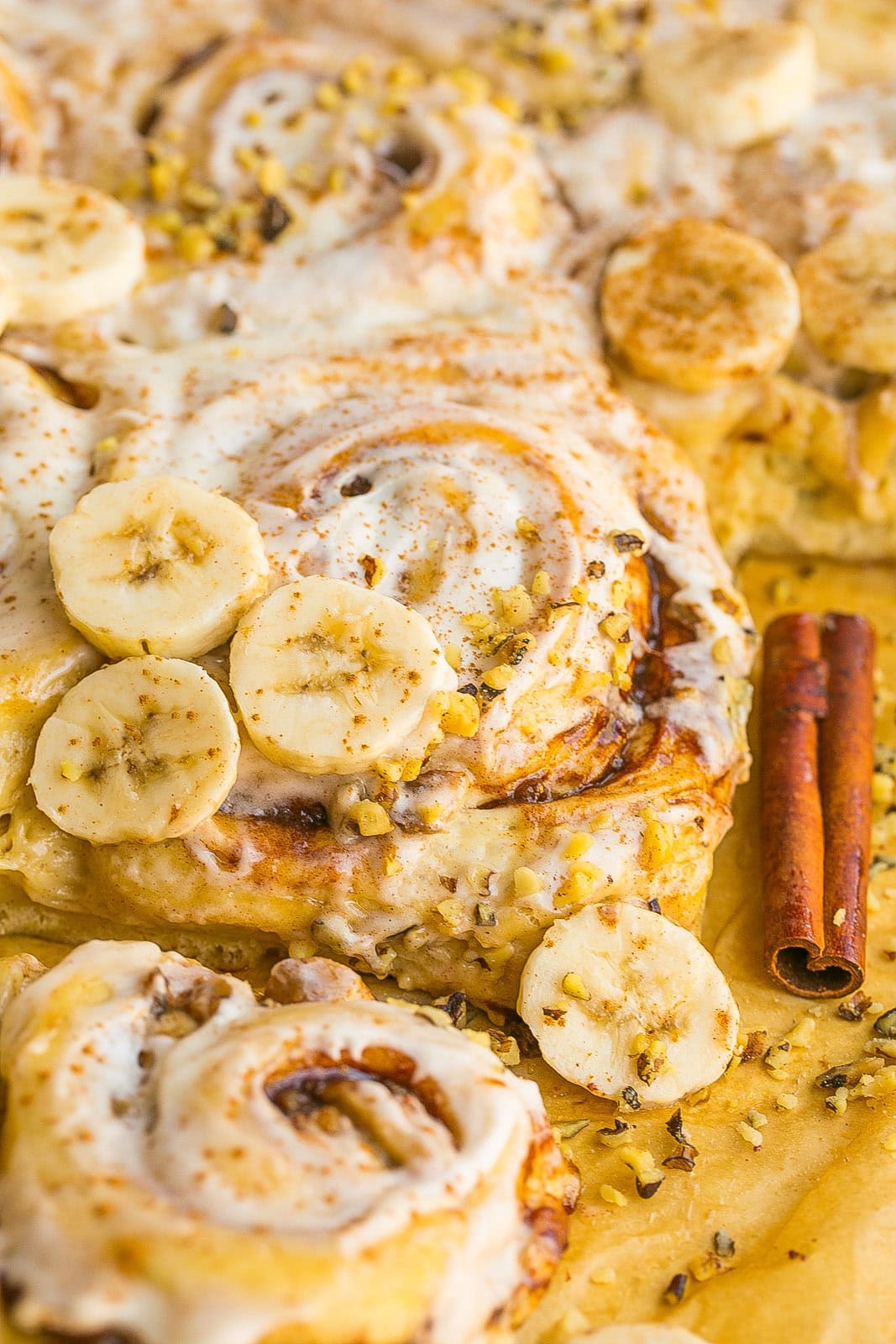 Soft and fluffy Banana Bread Cinnamon Rolls with cinnamon swirls, fresh banana slices, and cream cheese frosting.