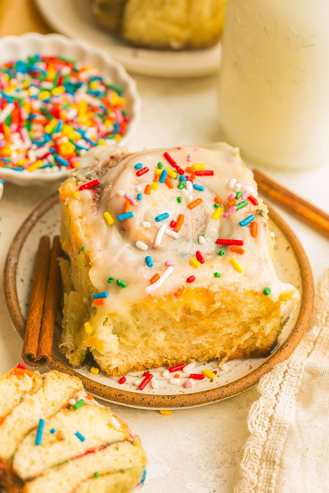 Soft and fluffy funfetti cinnamon roll with colorful sprinkles and sweet cream cheese frosting.