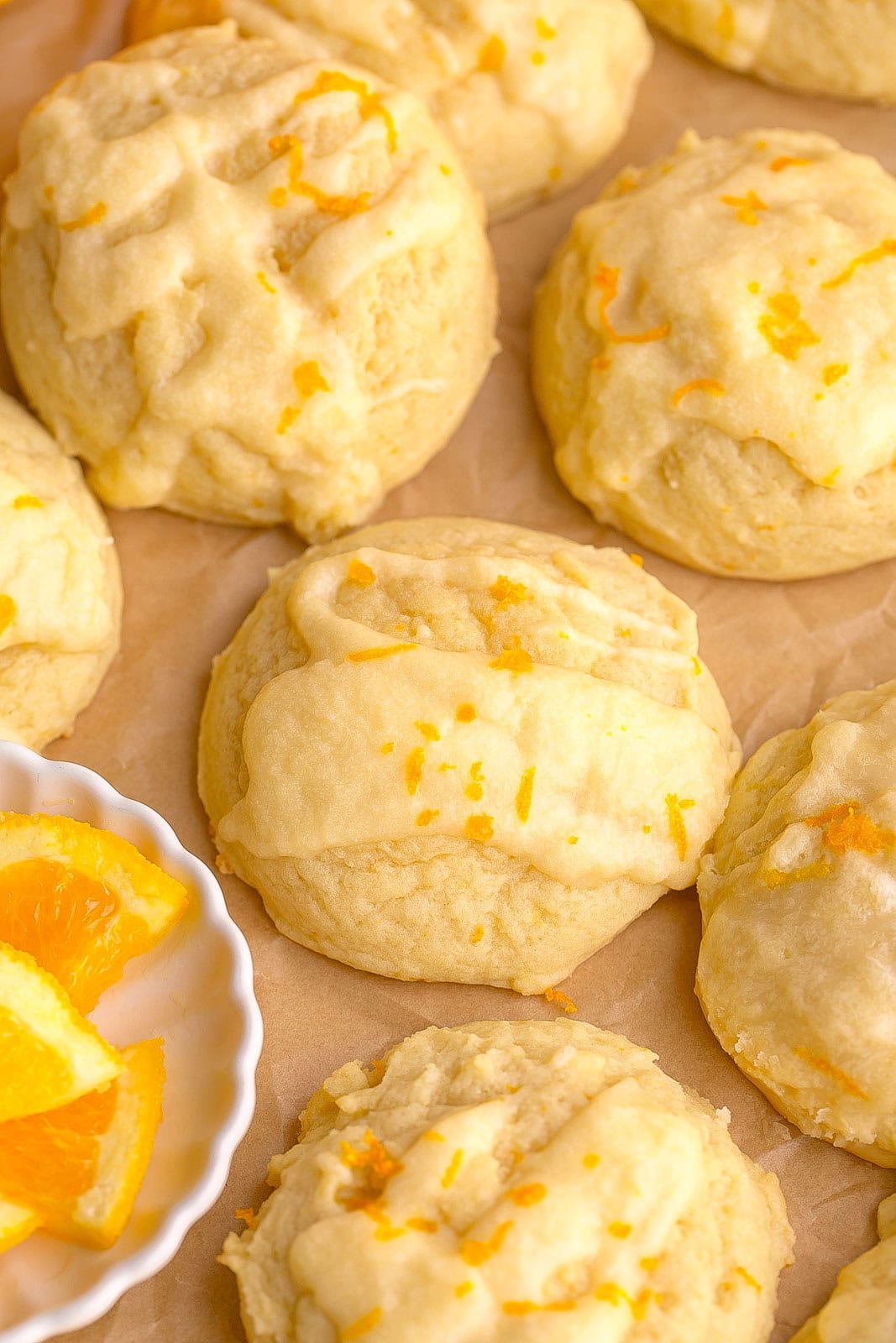 Close-up of chewy orange sugar cookies on a plate with citrus frosting and bright orange flavor.