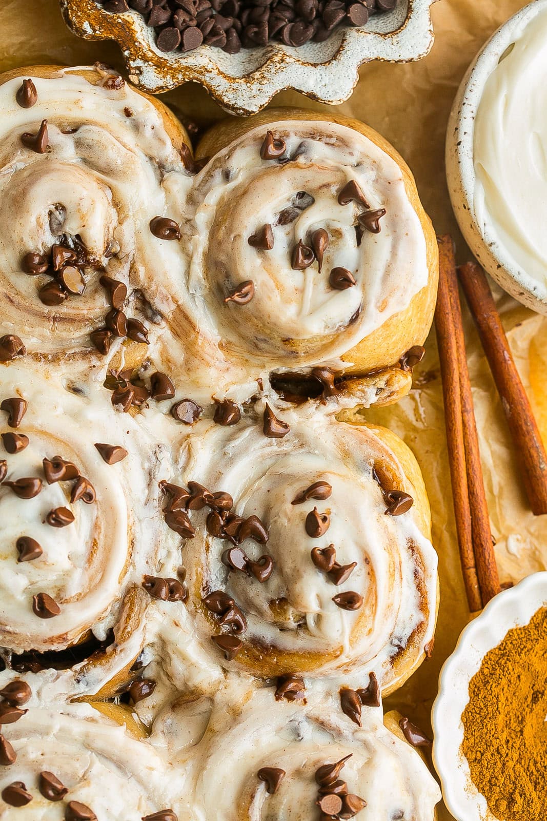 Soft cinnamon rolls topped with cream cheese glaze and chocolate chips.