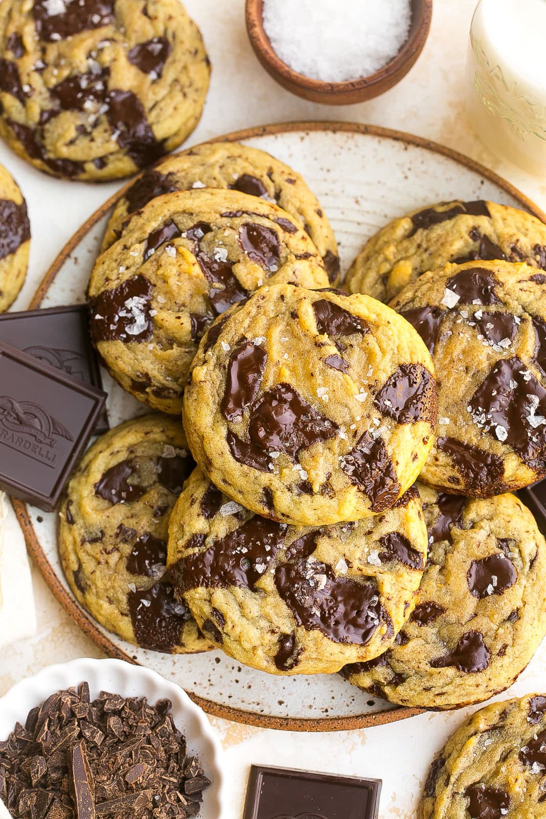 A plate full of dark chocolate chunk cookies with sea salt.