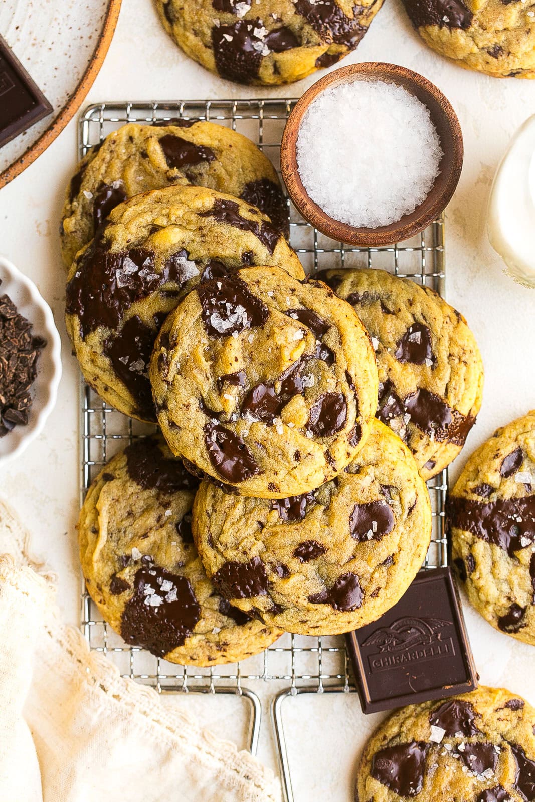 A pile of dark chocolate chip cookies on cooling rack.