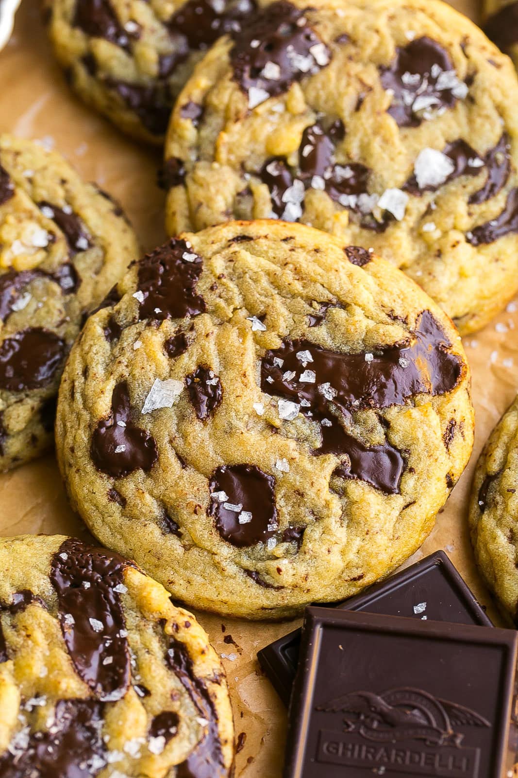 Bakery-style dark chocolate chip cookies on parchment paper.