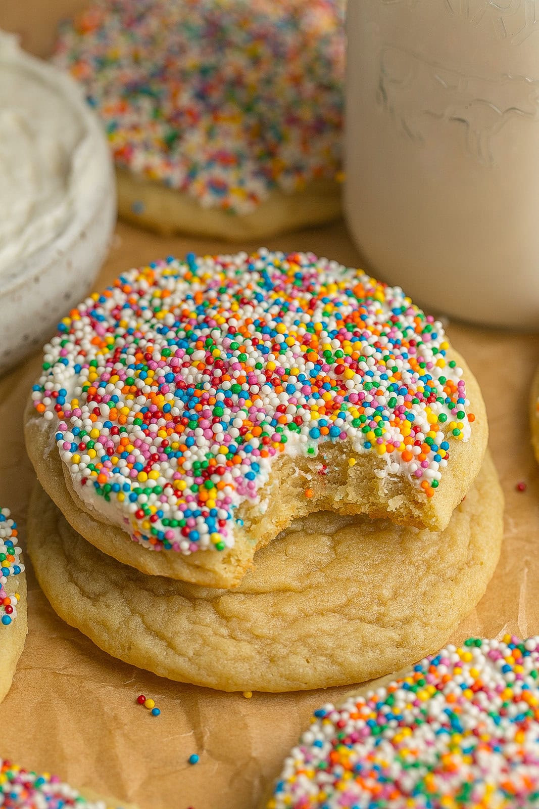 Bite mark in colorful Frosted Sugar Cookies with Sprinkles made from scratch and decorated with rainbow sprinkles.