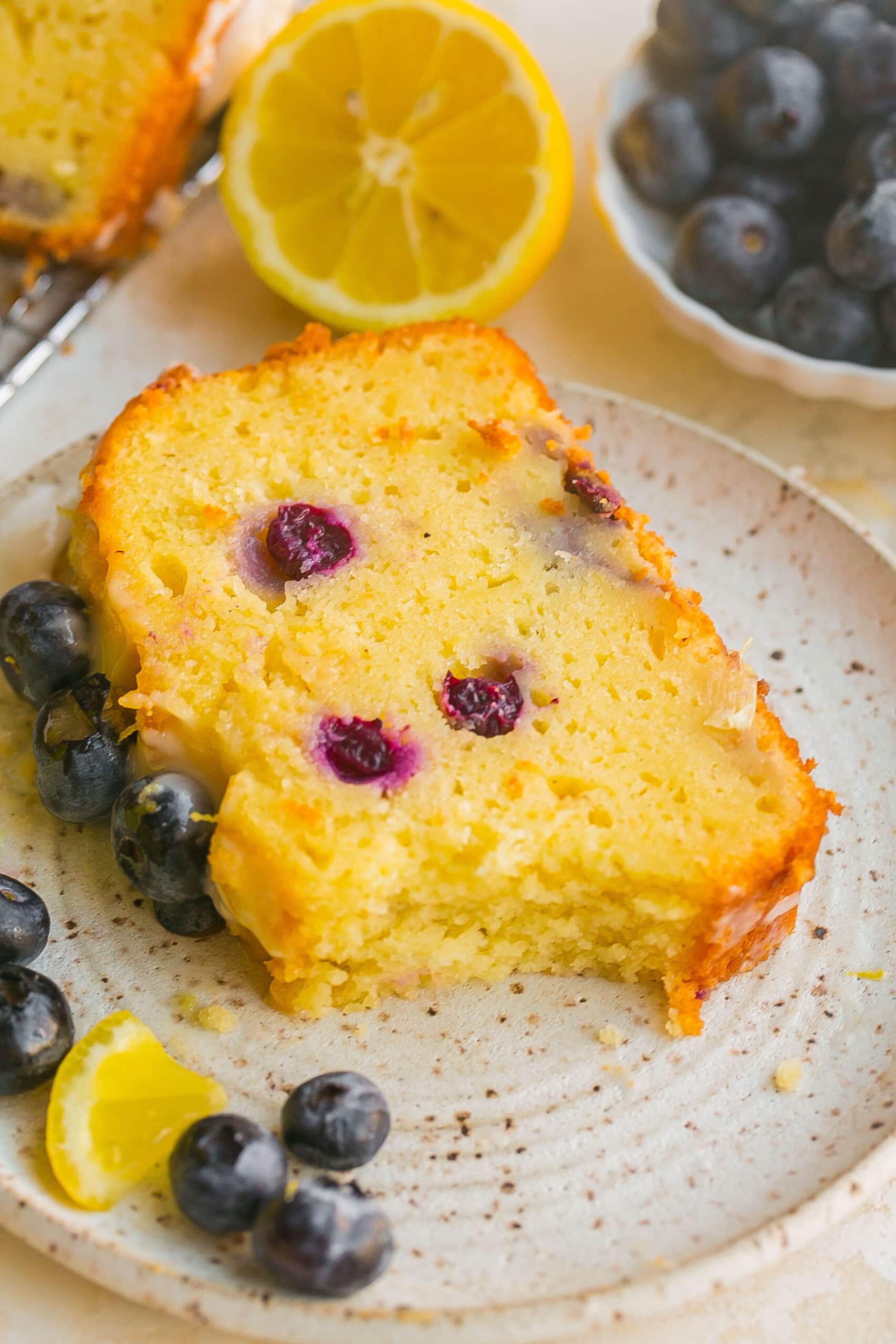 Blueberry Lemon Loaf Cake with bite mark on a plate.