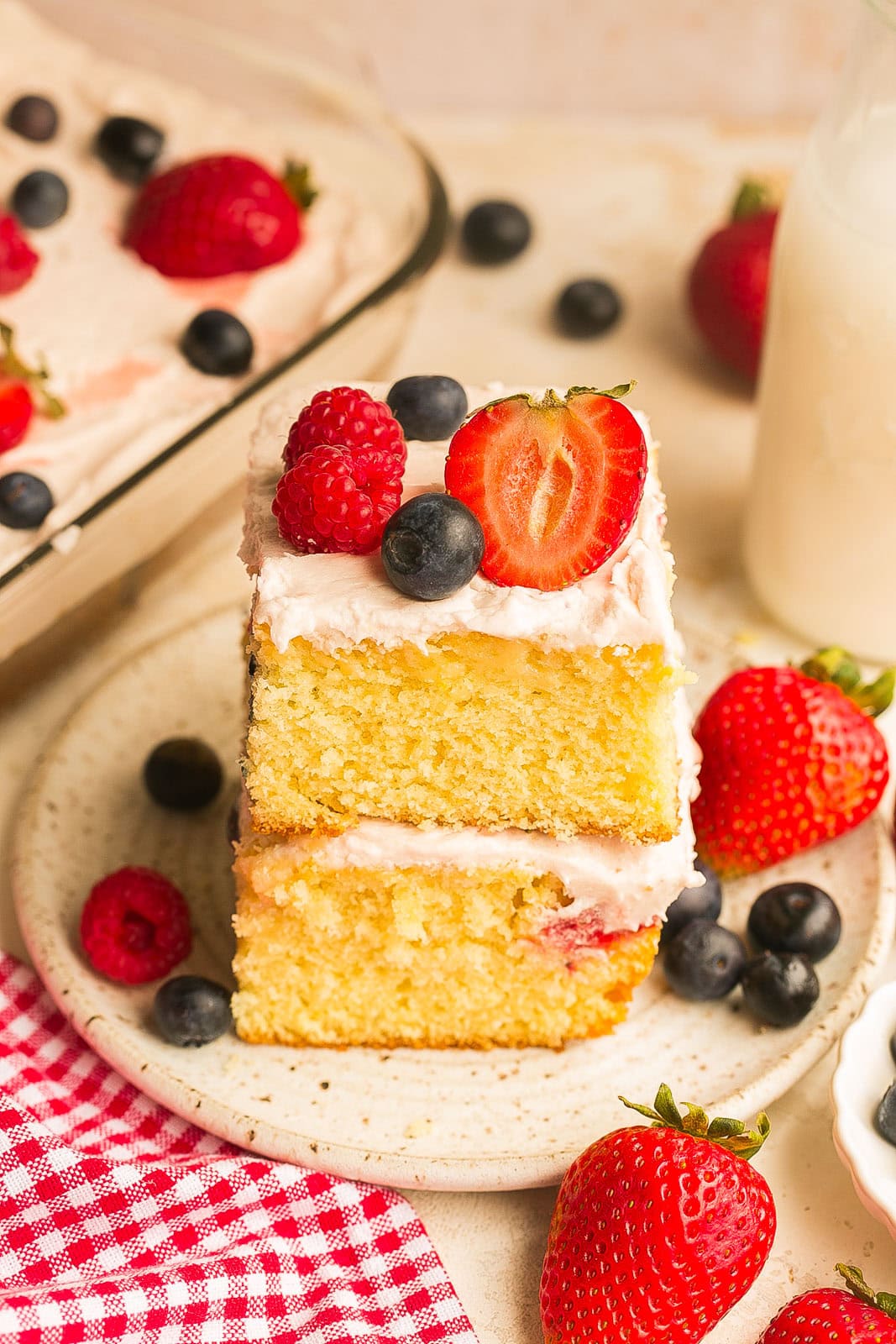 A perfect slice of stacked Berry Cake with fresh summer berries and jam infused frosting.