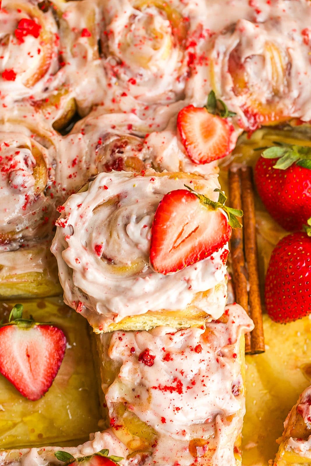 Fluffy strawberry sweet rolls with creamy icing and fresh strawberries.