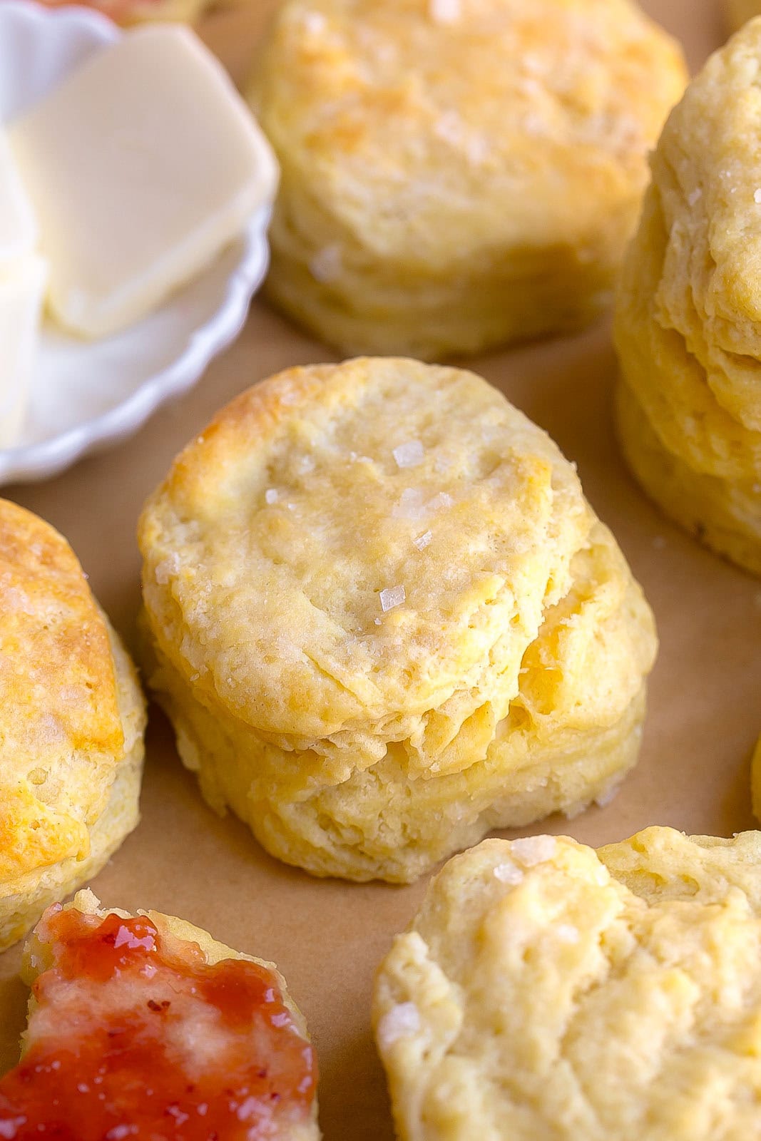 Close up of warm Homemade Buttermilk Biscuits ready to serve with butter and jam.