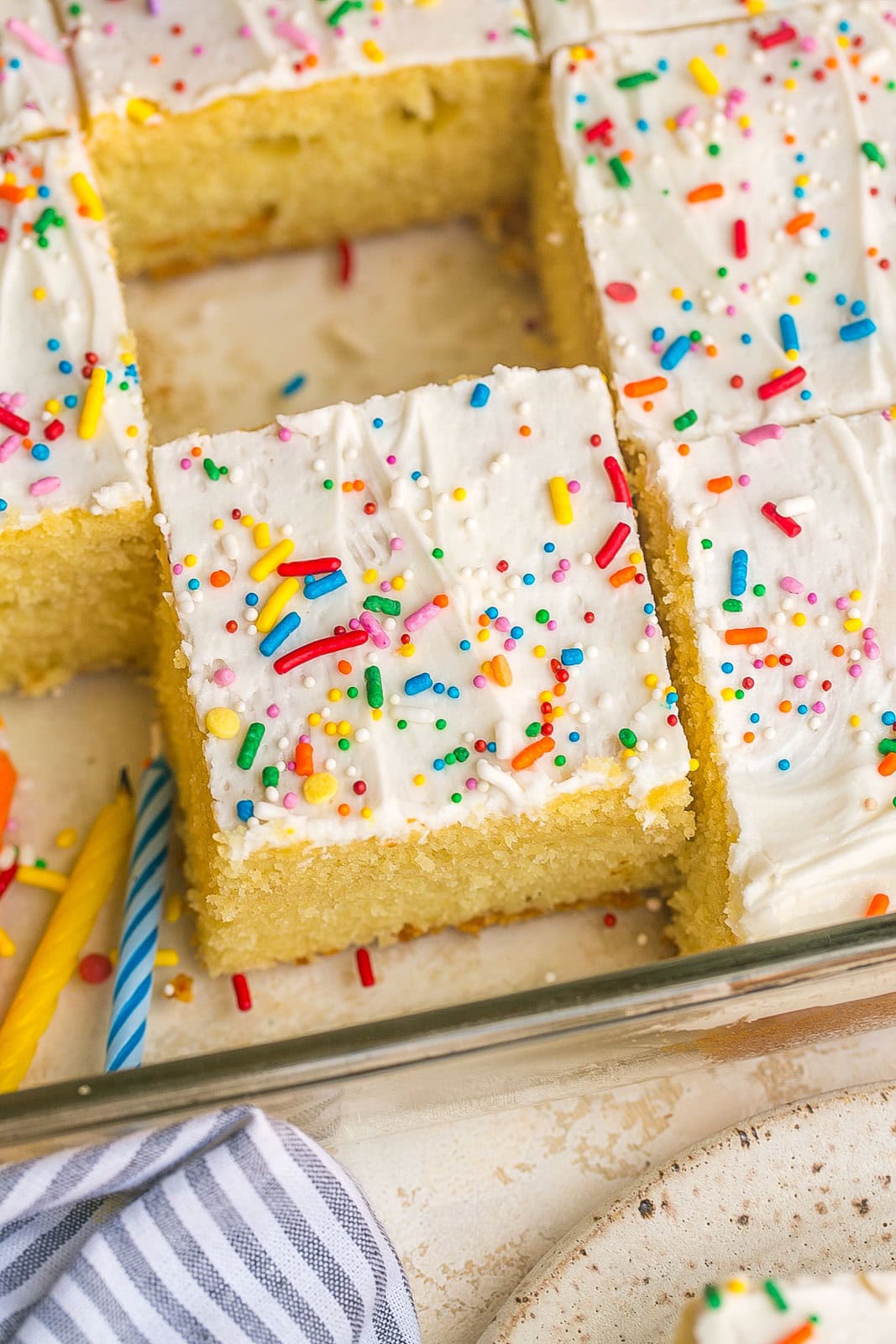 Vanilla Sheet Cake topped with creamy homemade vanilla buttercream frosting and colorful sprinkles.