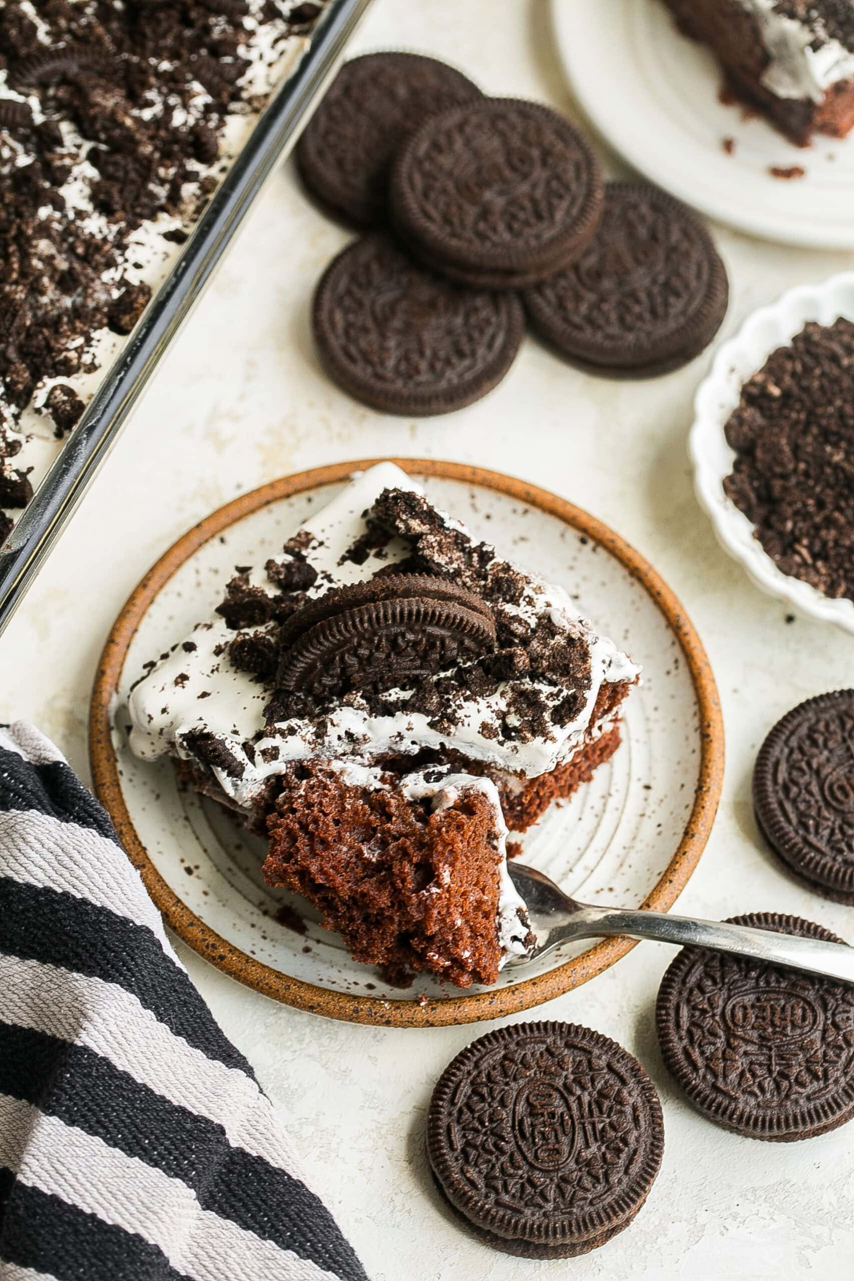 A plate of cake with a fork cutting through it.