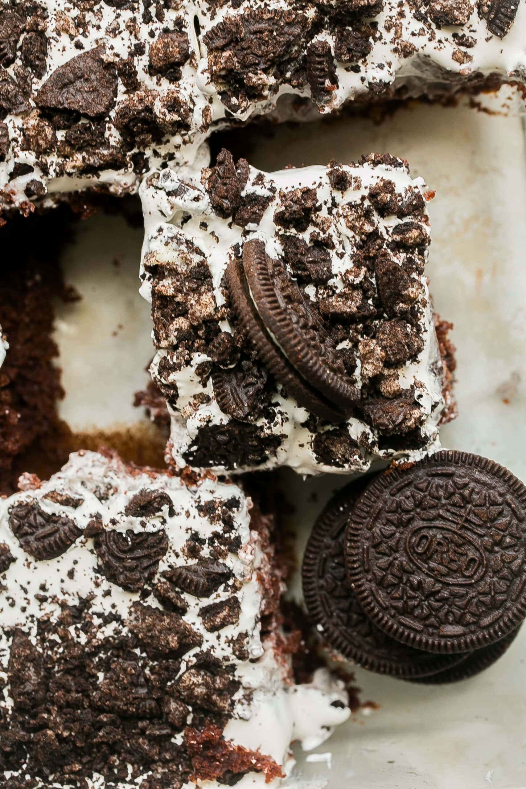 Easy Oreo Poke Cake made with chocolate cake, creamy cookies and cream pudding, whipped topping, and crushed Oreo cookies.